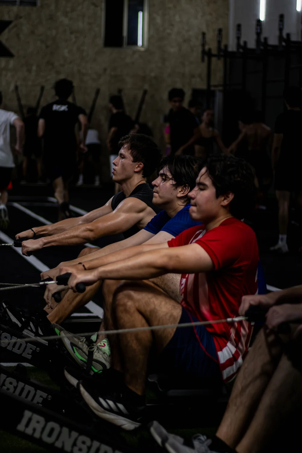 Varias personas entrenando en máquinas de remo durante una clase en Axion